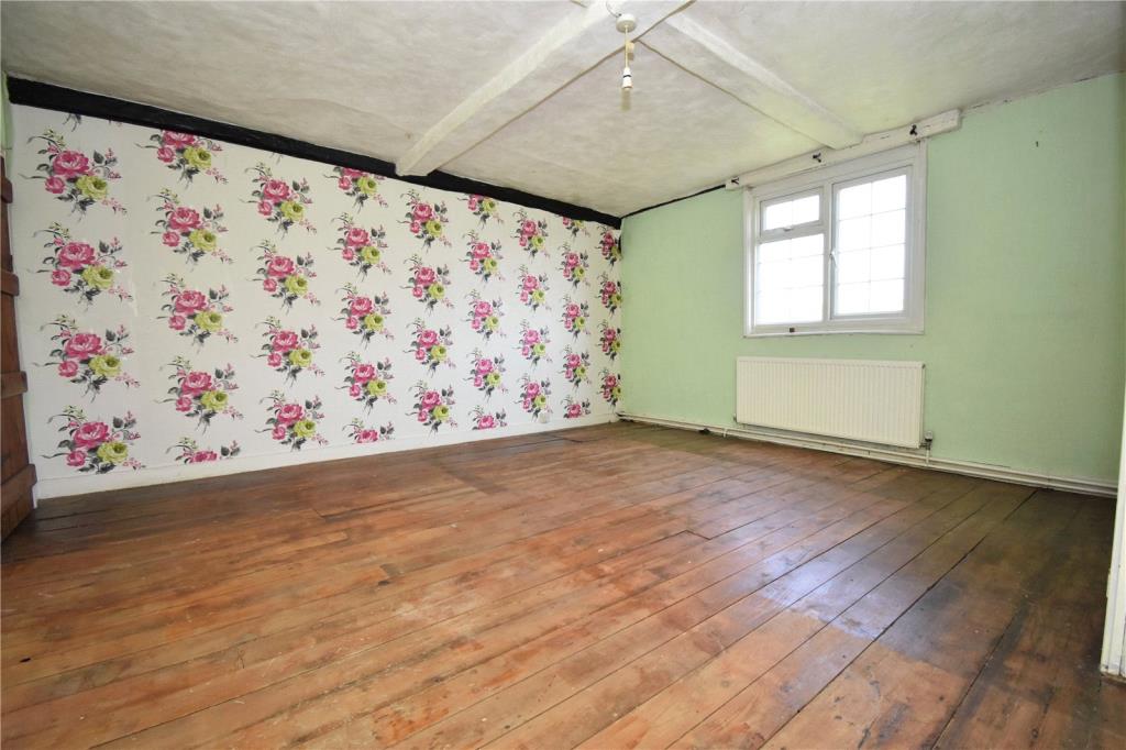 Lot: 103 - SEMI-DETACHED FARM COTTAGE FOR IMPROVEMENT - Bedroom 1 with wooden floors and beams
